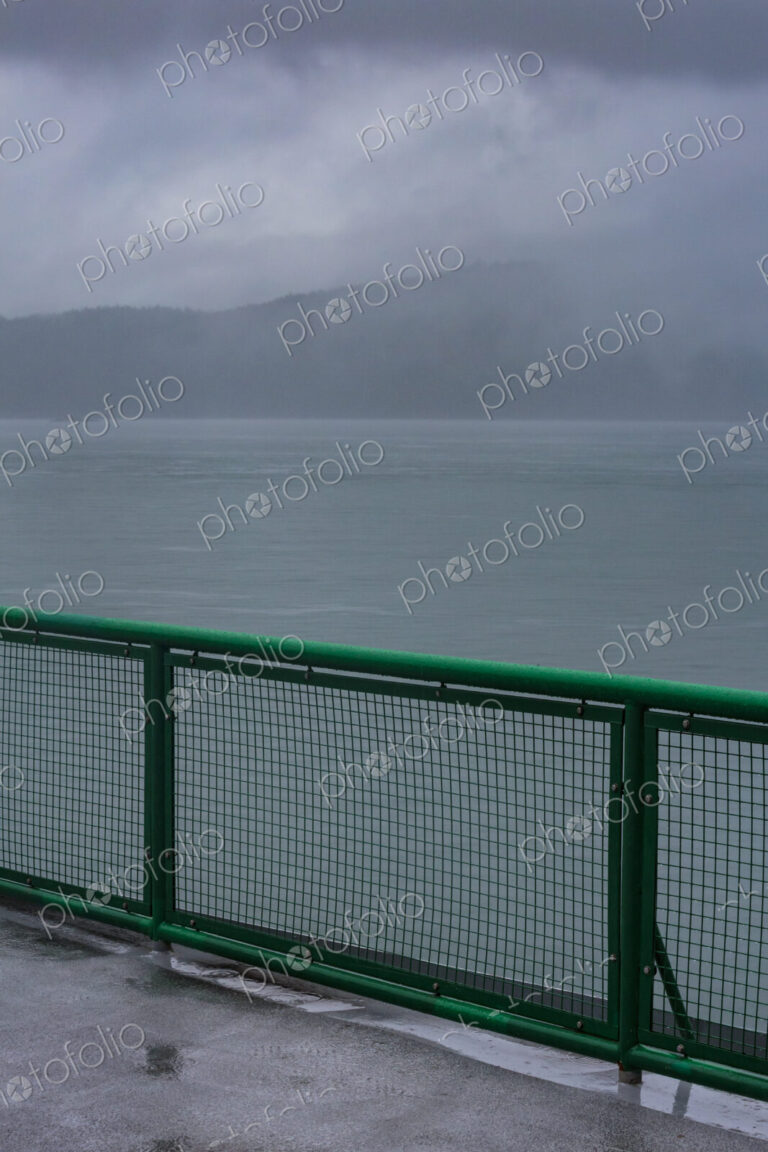 Ferry deck and railing on a boat sailing past the San Juan Islands