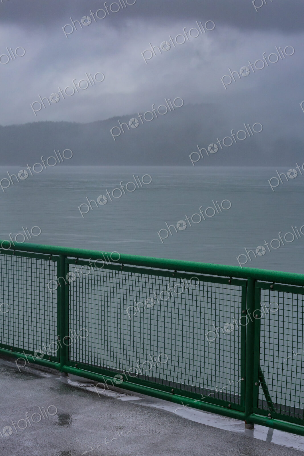 Ferry deck and railing on a boat sailing past the San Juan Islands