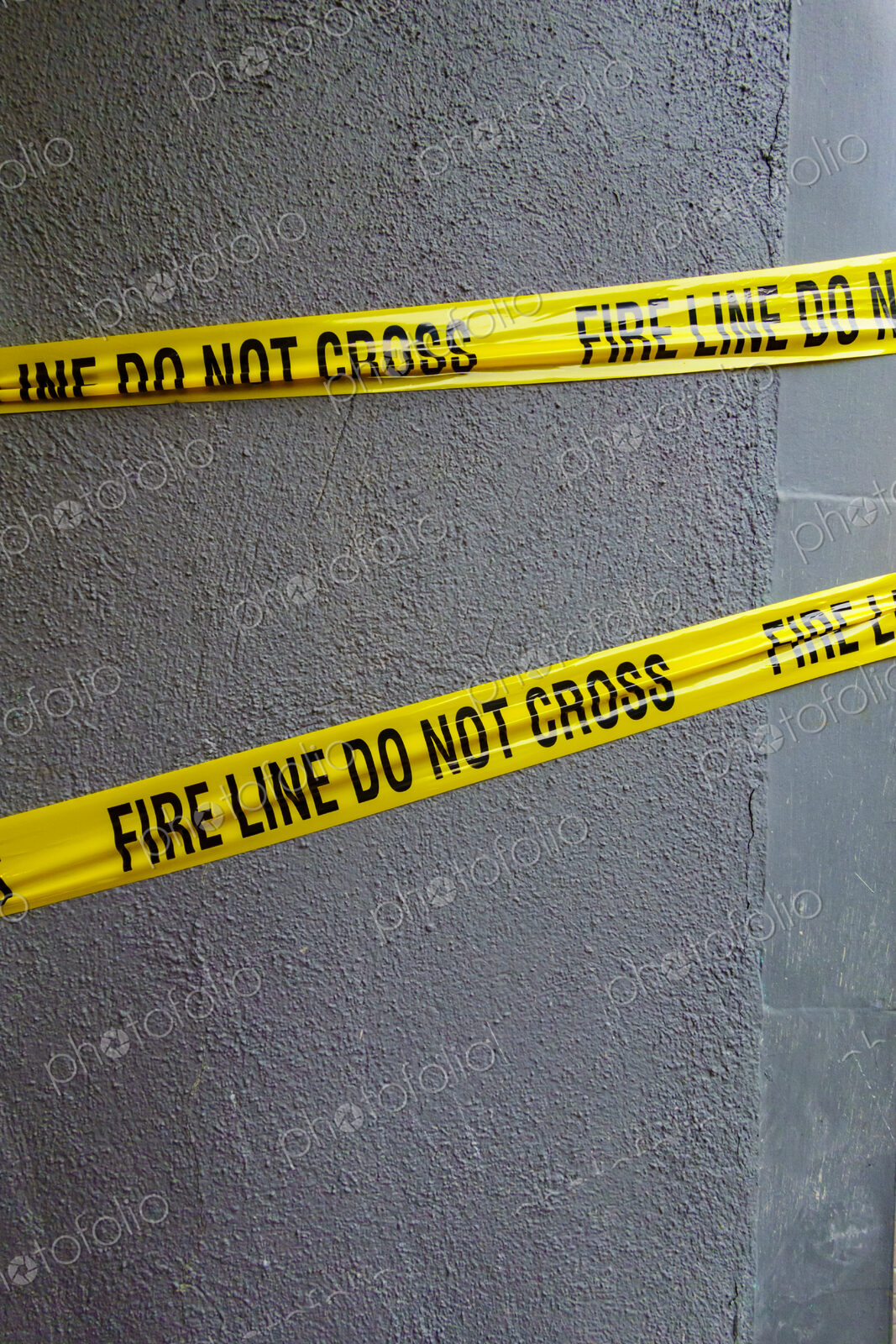 Fire Line Do Not Cross tape, yellow tape with black lettering stretched across a wall.