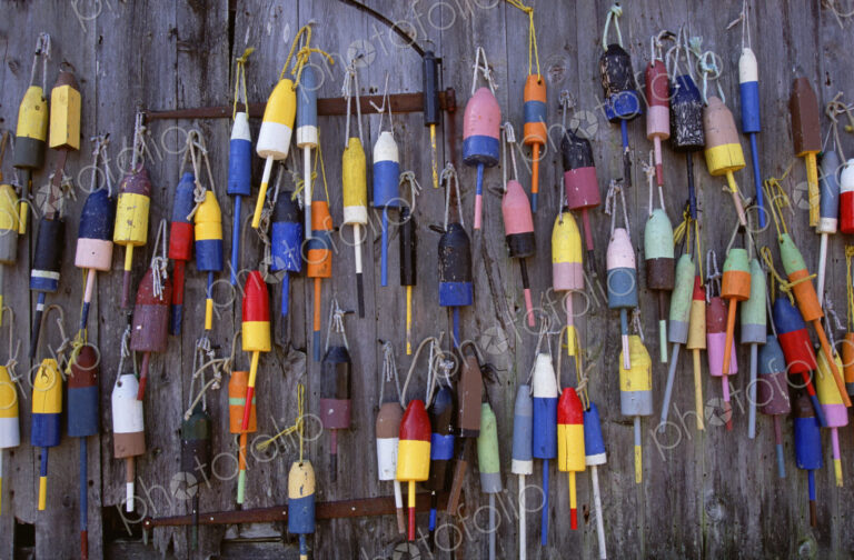 Fishing marker marine buoys or floats hanging on a fishing shed wall on the waterfront.