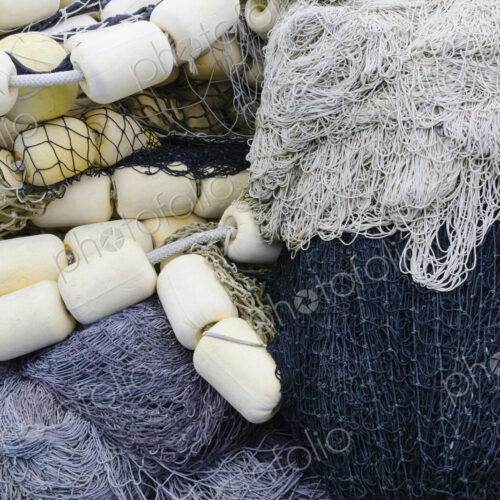 Fishing nets and floats, commercial fishing eqiuipment in a heap on a quayside. Fishing nets and floats, commercial fishing eqiuipment in a heap on a quayside.