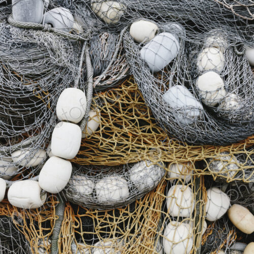 Fishing nets and floats, commercial fishing eqiuipment in a heap on a quayside. Fishing nets and floats, commercial fishing eqiuipment in a heap on a quayside.
