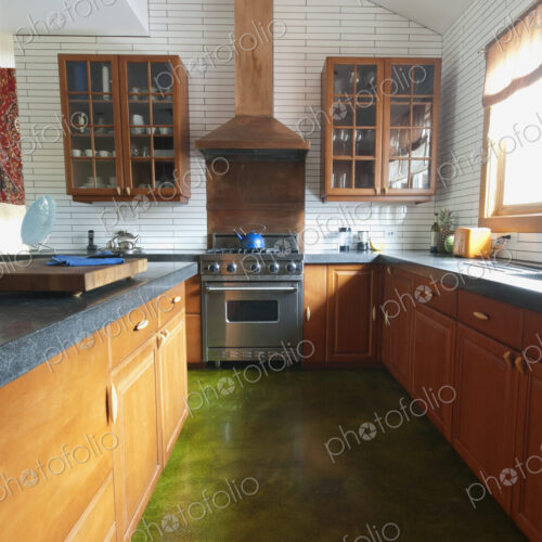 Fitted kitchen units, shelves and sink by the window. A central island with smooth… Fitted kitchen units, shelves and sink by the window. A central island with smooth…