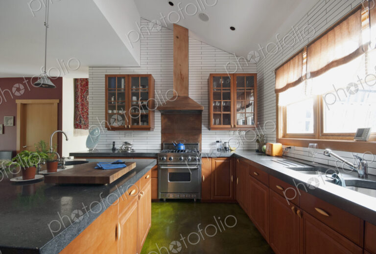 Fitted kitchen units, shelves,and sink by the window. A central island with smooth…