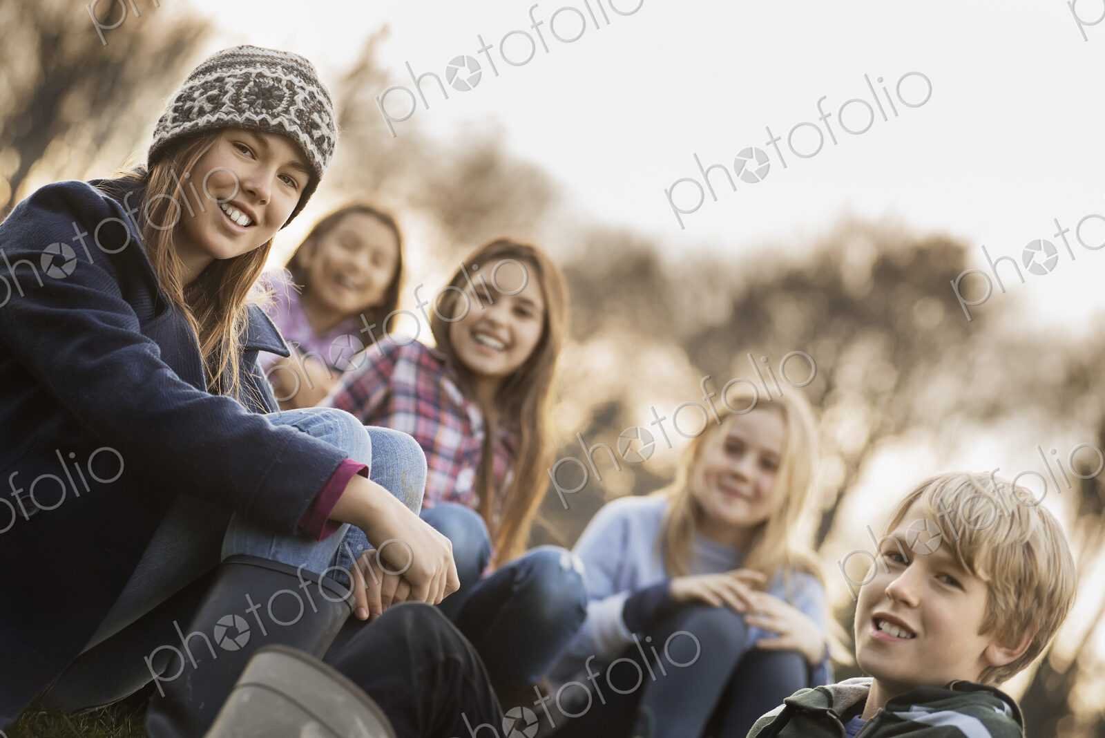Five children on a farm. Boys and girls in warm jackets outdoors.
