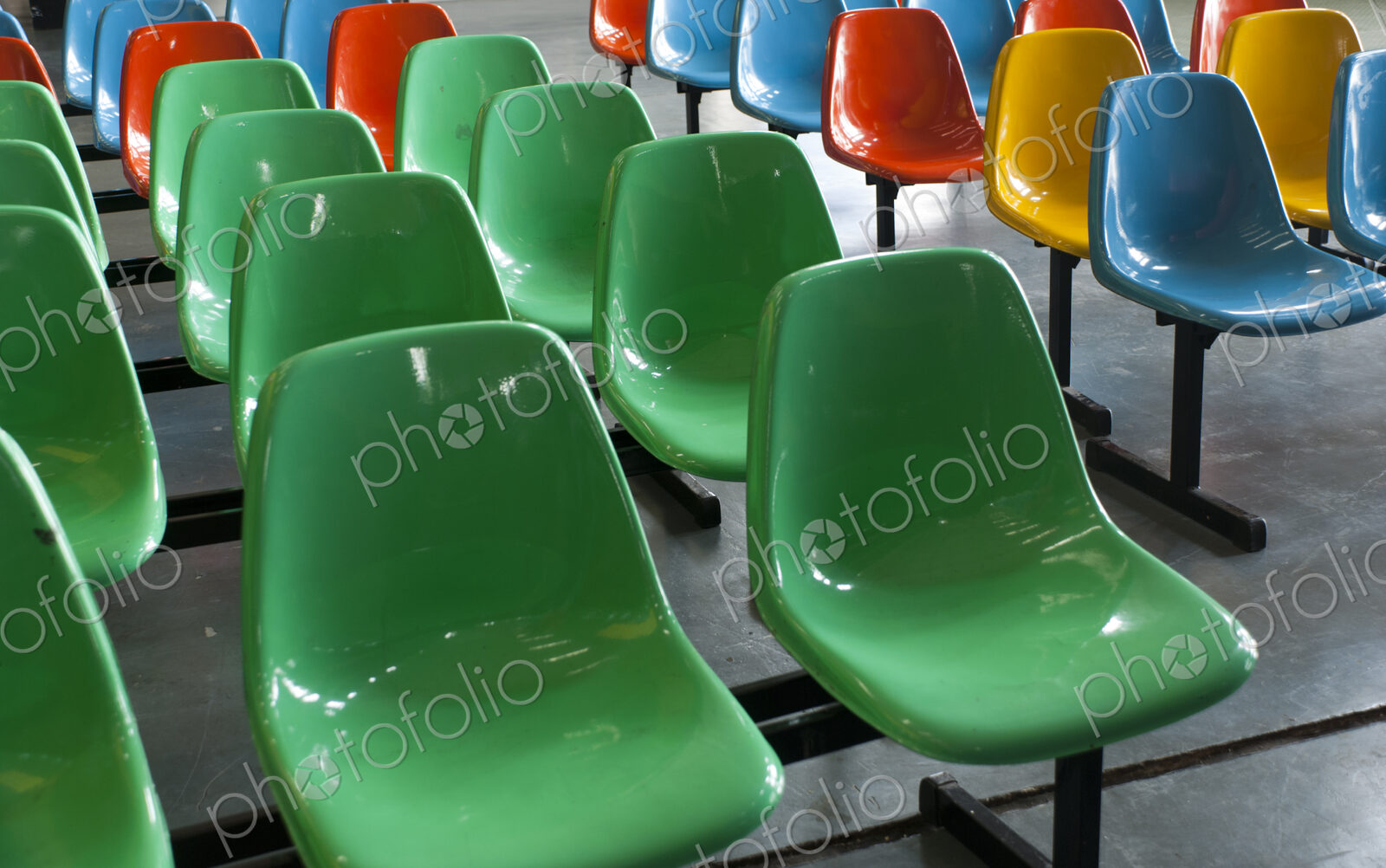 Fixed seats on a metal framework, plastic coloured shapes. Red, green, blue and yellow.