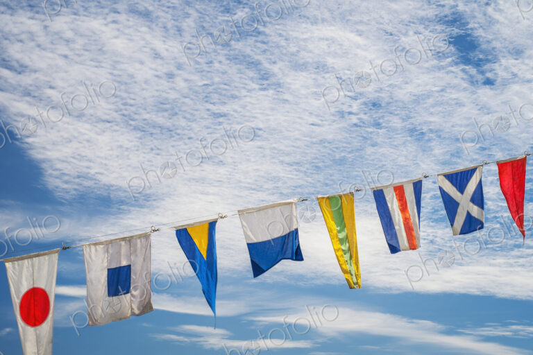 Flags flying against blue sky