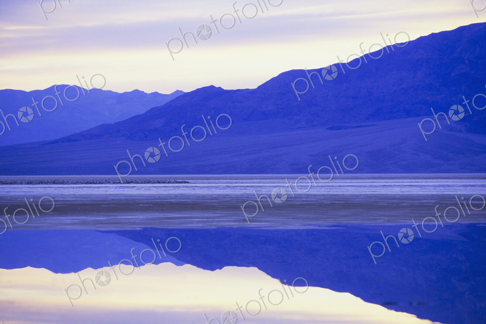 Flooded salt flats at dawn and Panamint Mountains in distance.