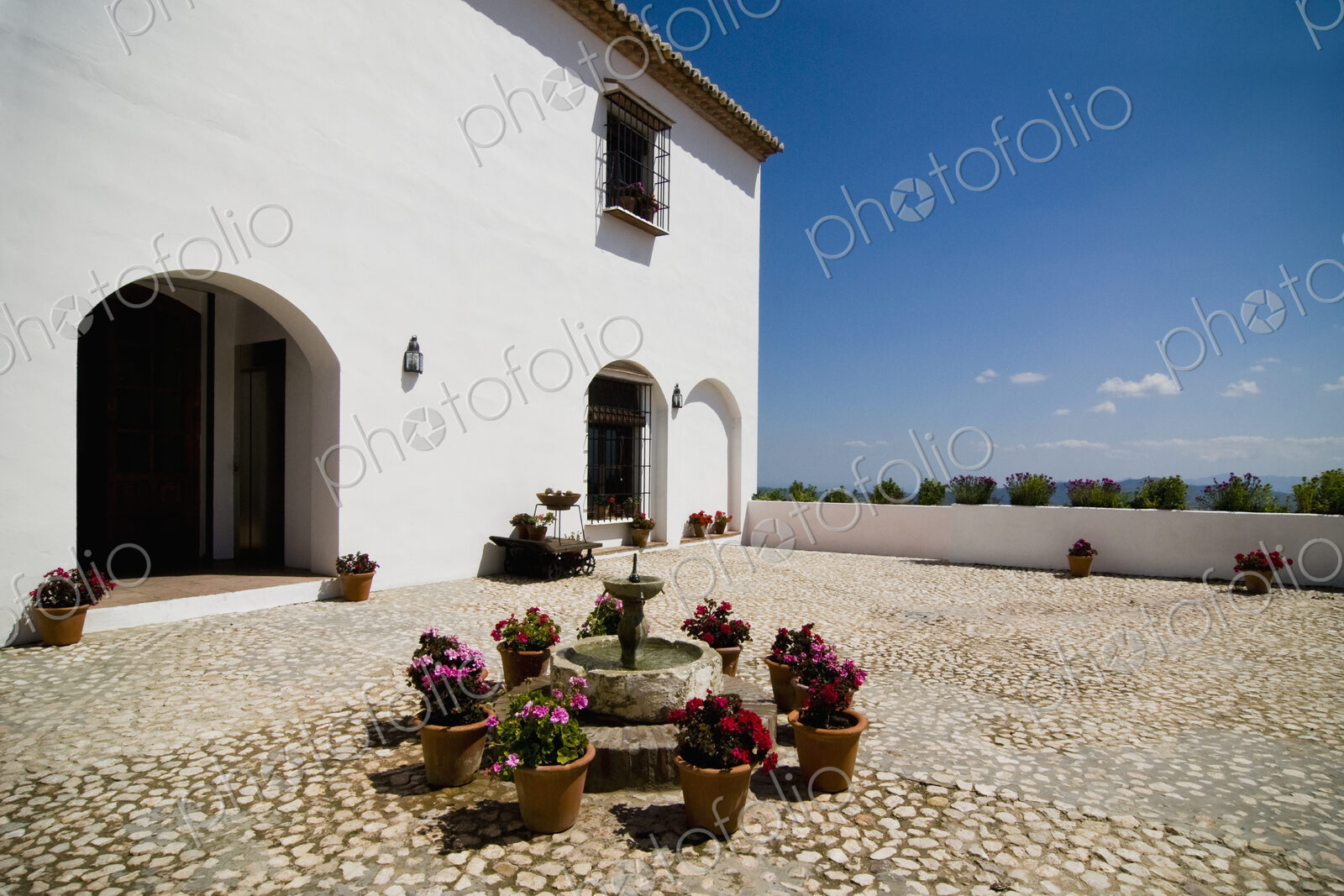 Flowerpots around fountain outside villa
