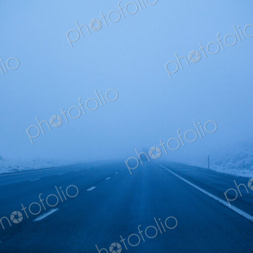 Foggy winter highway, the Interstate 90 at dusk, driving in poor visibility. Foggy winter highway, the Interstate 90 at dusk, driving in poor visibility.