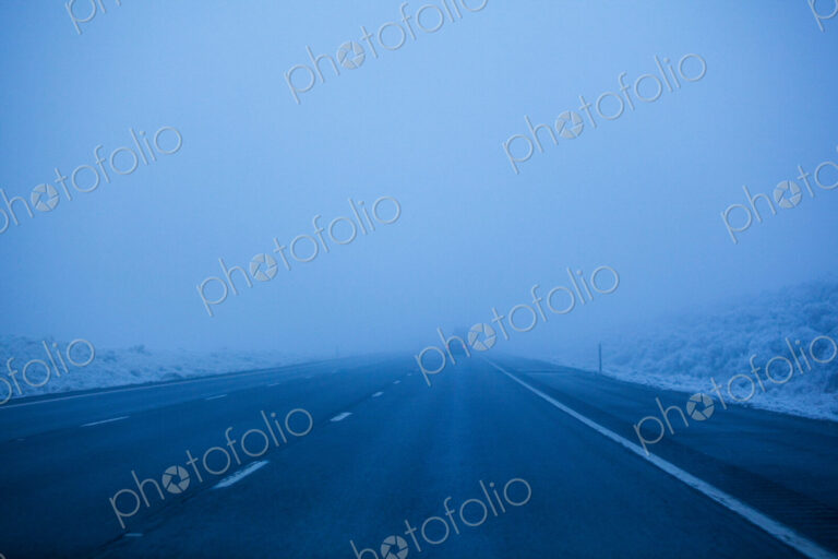 Foggy winter highway, the Interstate 90 at dusk, driving in poor visibility.