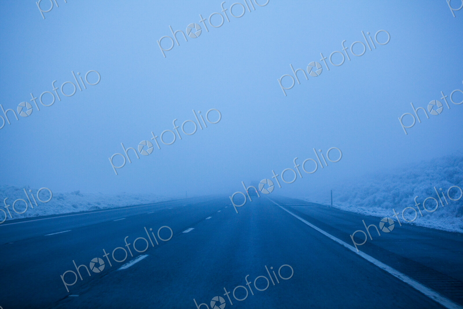 Foggy winter highway, the Interstate 90 at dusk, driving in poor visibility.