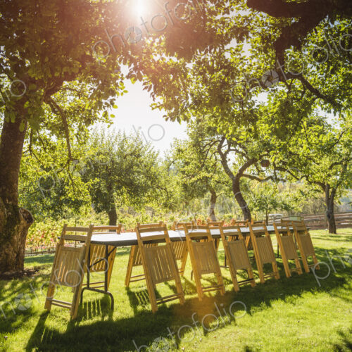Folded chairs leaning on table in backyard
