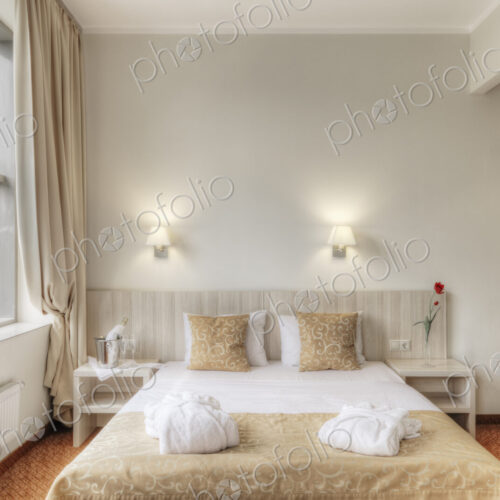 Folded robes on bed in hotel room