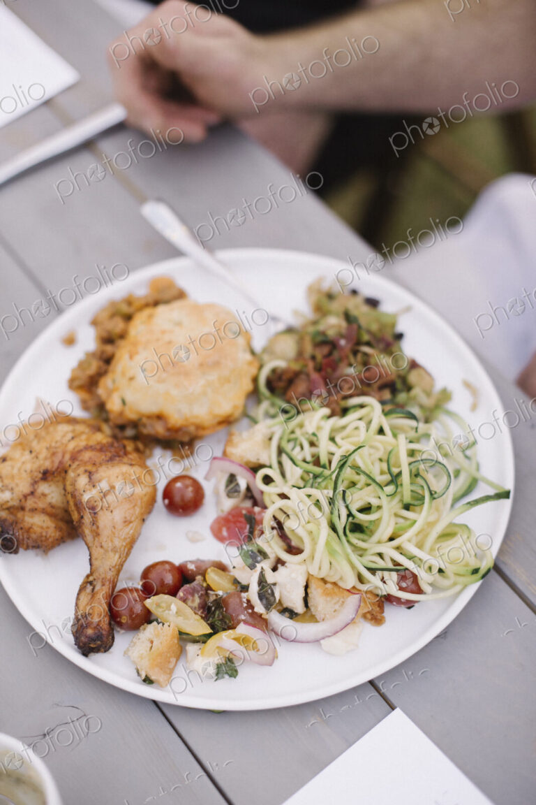 Food on a plate at a garden party, grilled chicken and salad.