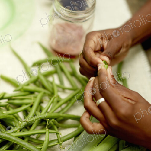 Food preparation outdoors. View onto a table, and a woman's hands preparing fresh…