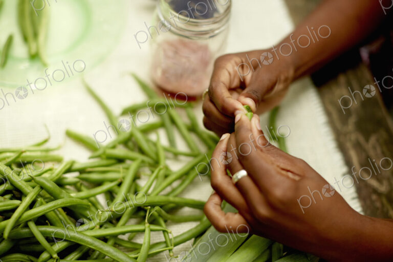 Food preparation outdoors. View onto a table, and a woman's hands preparing fresh…