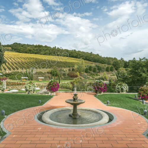 Fountain and walkway in landscaped grounds over rural fields, Radda in Chianti, Siena,…