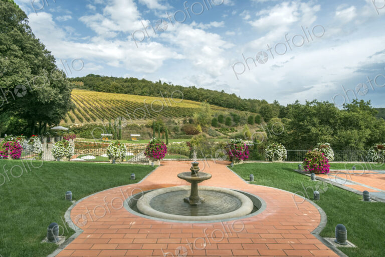 Fountain and walkway in landscaped grounds over rural fields, Radda in Chianti, Siena,…