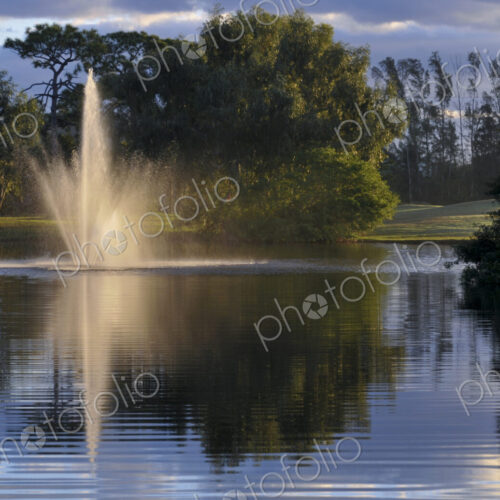 Fountain splashing in still lake