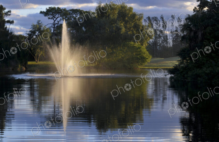 Fountain splashing in still lake
