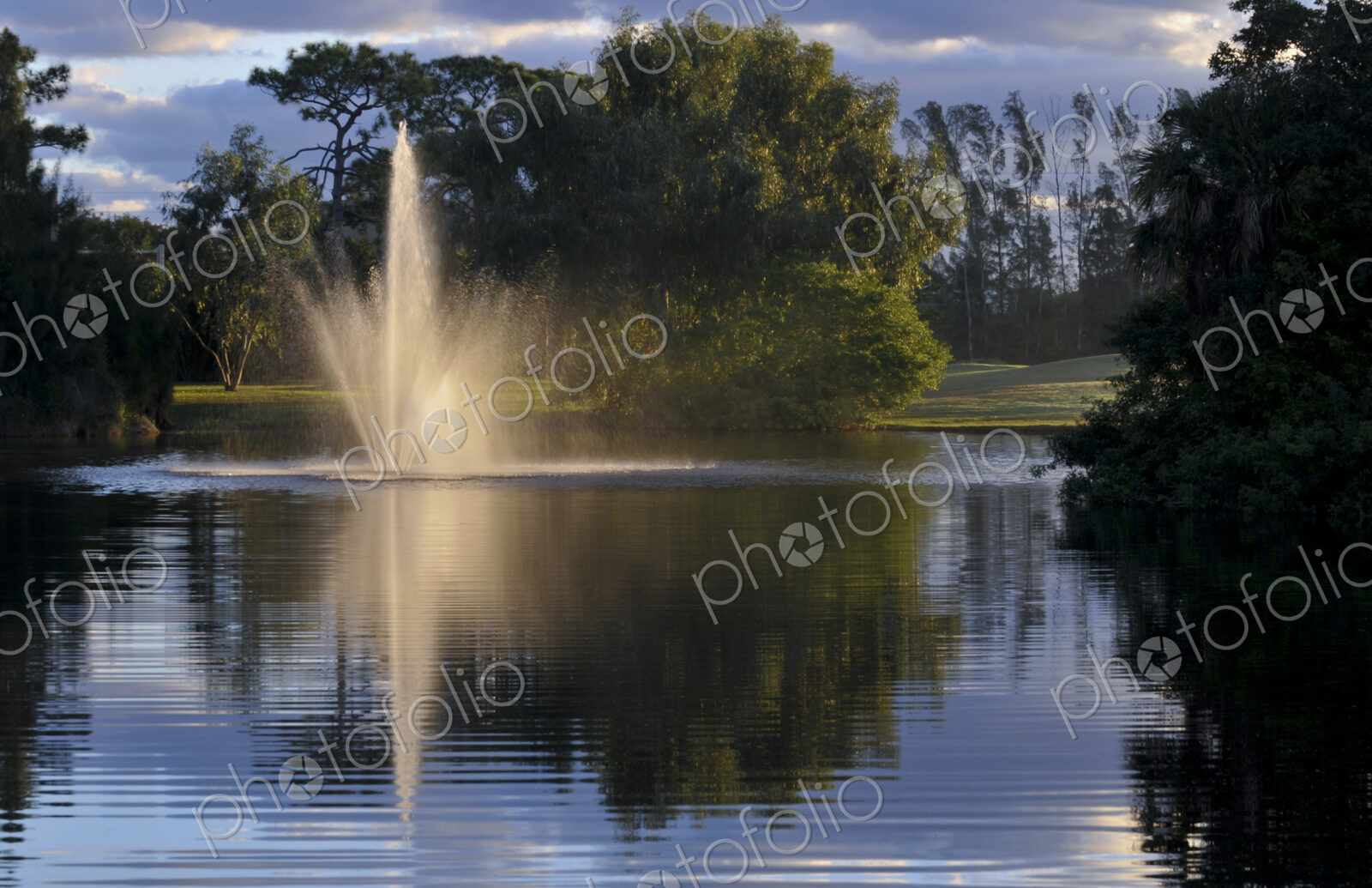 Fountain splashing in still lake