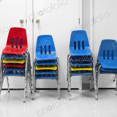Four piles of stacked plastic chairs. Four piles of stacked plastic chairs.