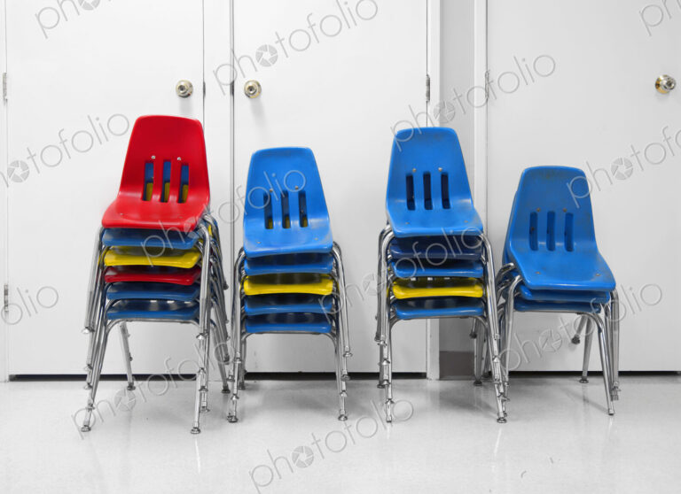 Four piles of stacked plastic chairs.