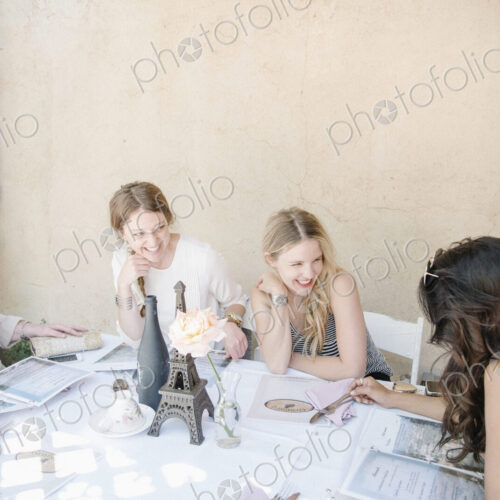 Four women sitting at a table, smiling and chatting. Four women sitting at a table, smiling and chatting.