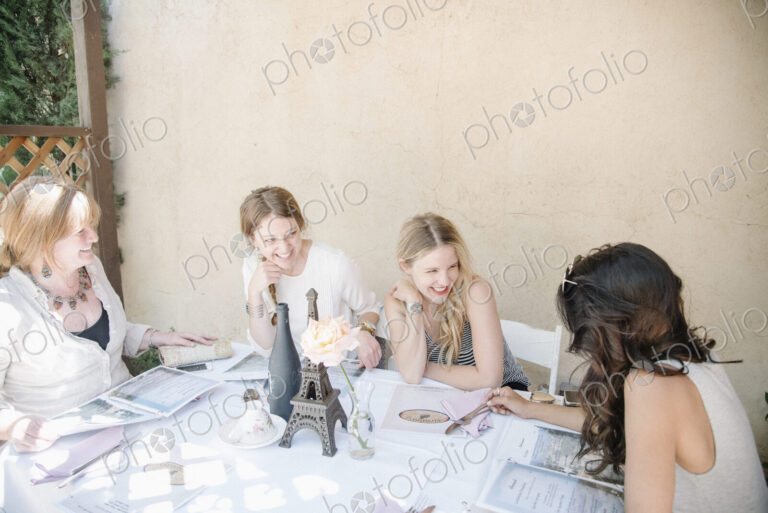 Four women sitting at a table, smiling and chatting.