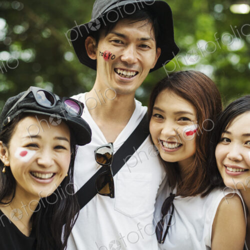 Four young people outdoors, faces painted with Japanese flags Four young people outdoors, faces painted with Japanese flags
