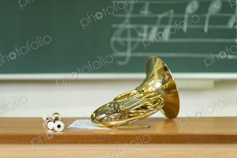 French horn sitting on desk in classroom