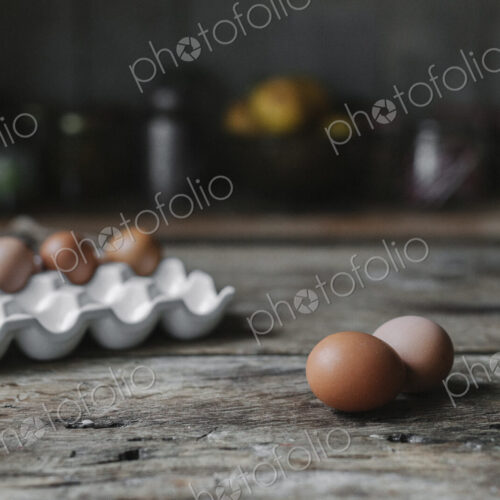 Fresh hen's eggs in a box and on a wooden table. Fresh hen's eggs in a box and on a wooden table.
