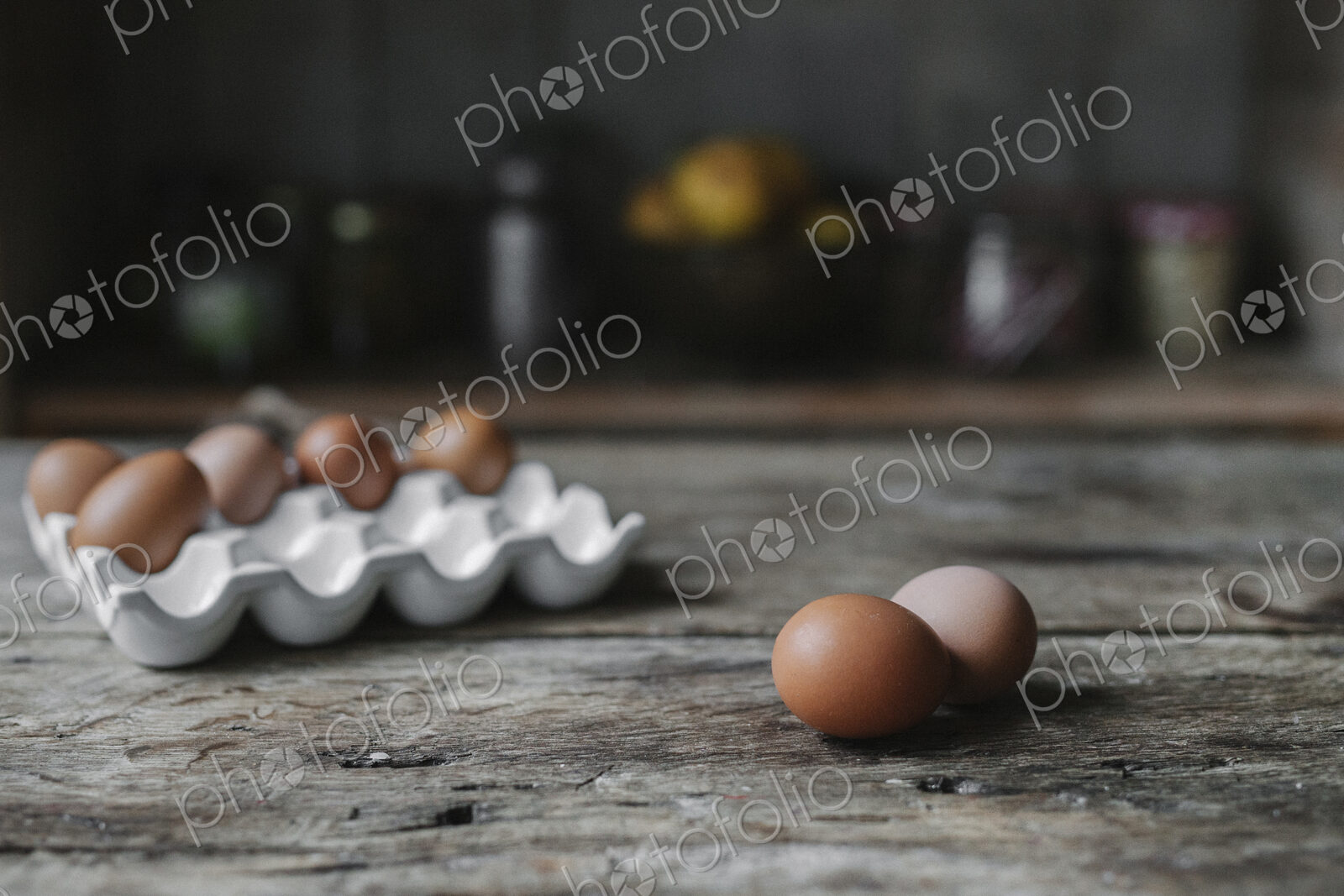 Fresh hen’s eggs in a box and on a wooden table.