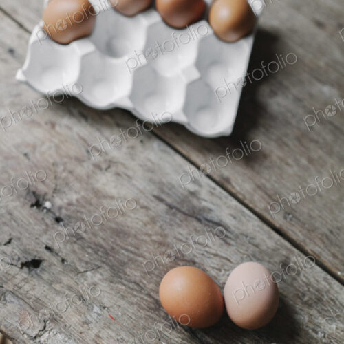 Fresh hen's eggs in a box and on a wooden table. Fresh hen's eggs in a box and on a wooden table.