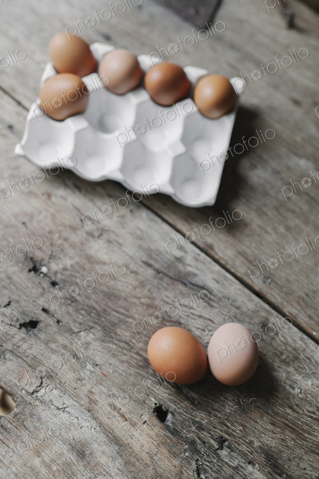 Fresh hen’s eggs in a box and on a wooden table.