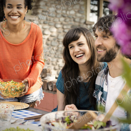 Friends around a table, men and women laughing and talking. Friends around a table, men and women laughing and talking.