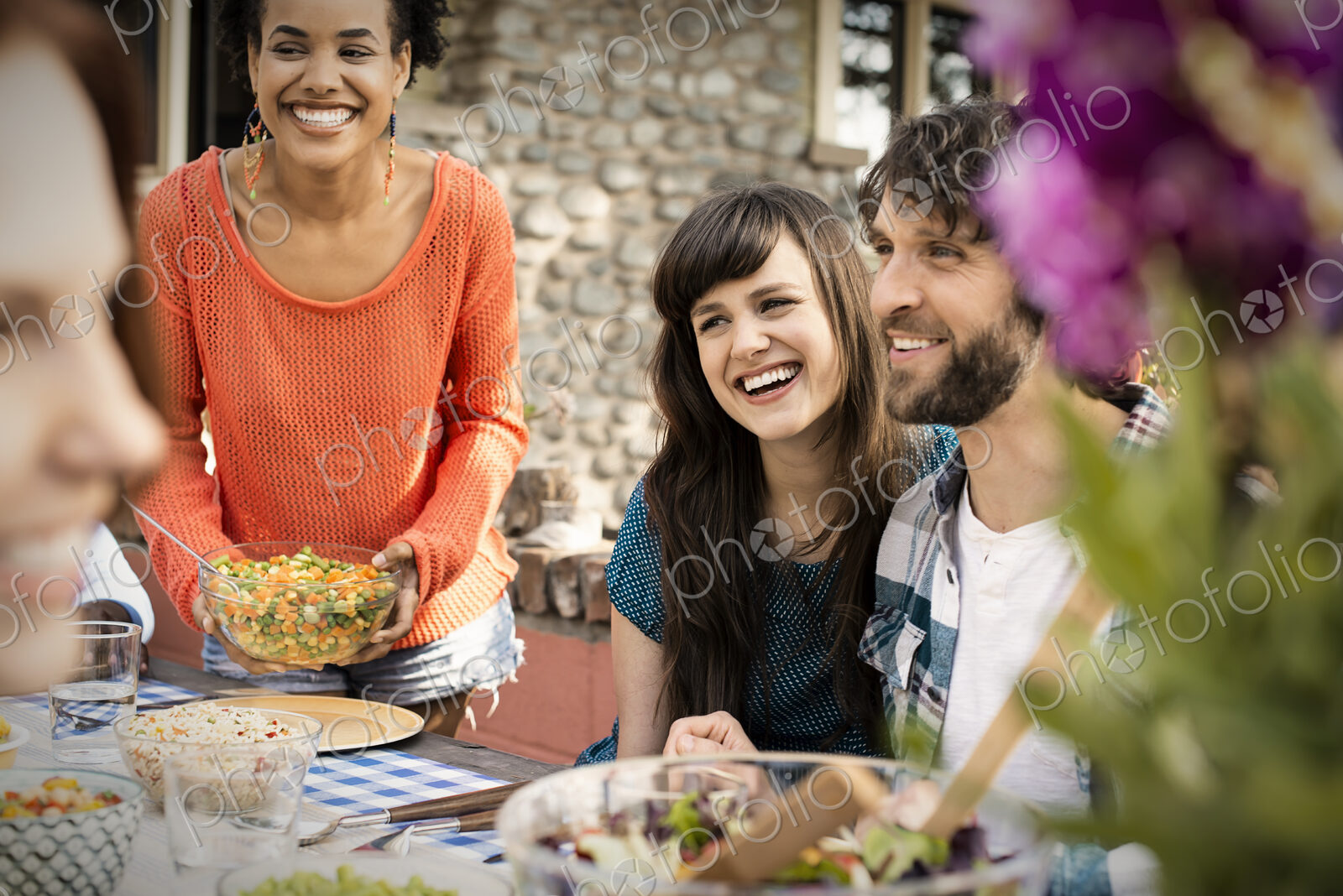 Friends around a table, men and women laughing and talking.