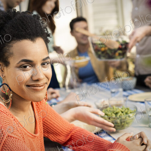 Friends around a table, men and women laughing and talking.