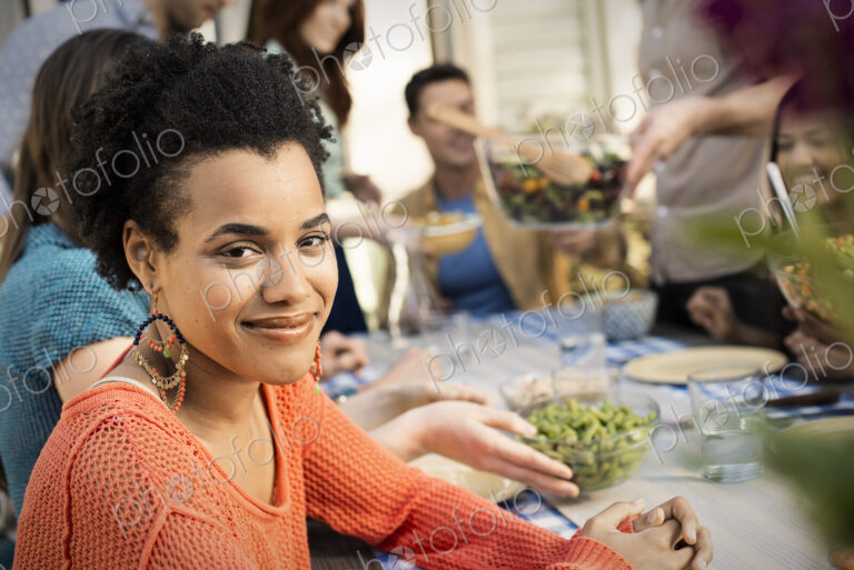 Friends around a table, men and women laughing and talking.
