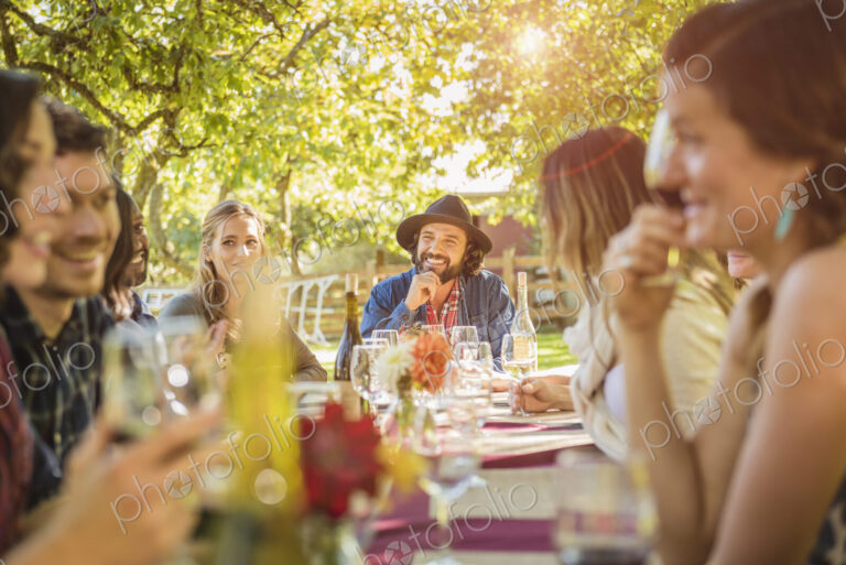 Friends drinking wine at party outdoors