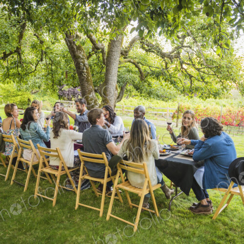 Friends enjoying wine at party outdoors Friends enjoying wine at party outdoors