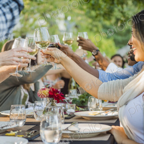 Friends toasting with wine at party outdoors Friends toasting with wine at party outdoors