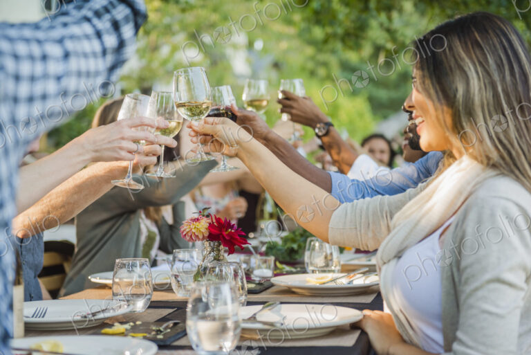 Friends toasting with wine at party outdoors