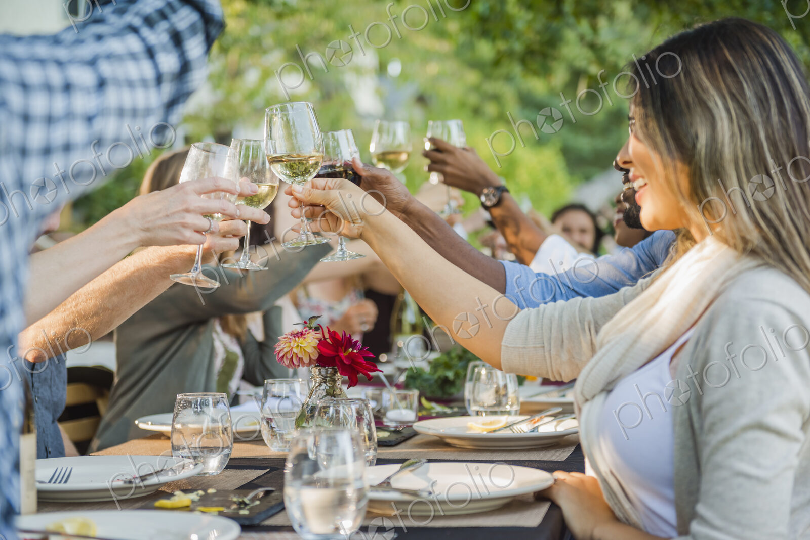 Friends toasting with wine at party outdoors