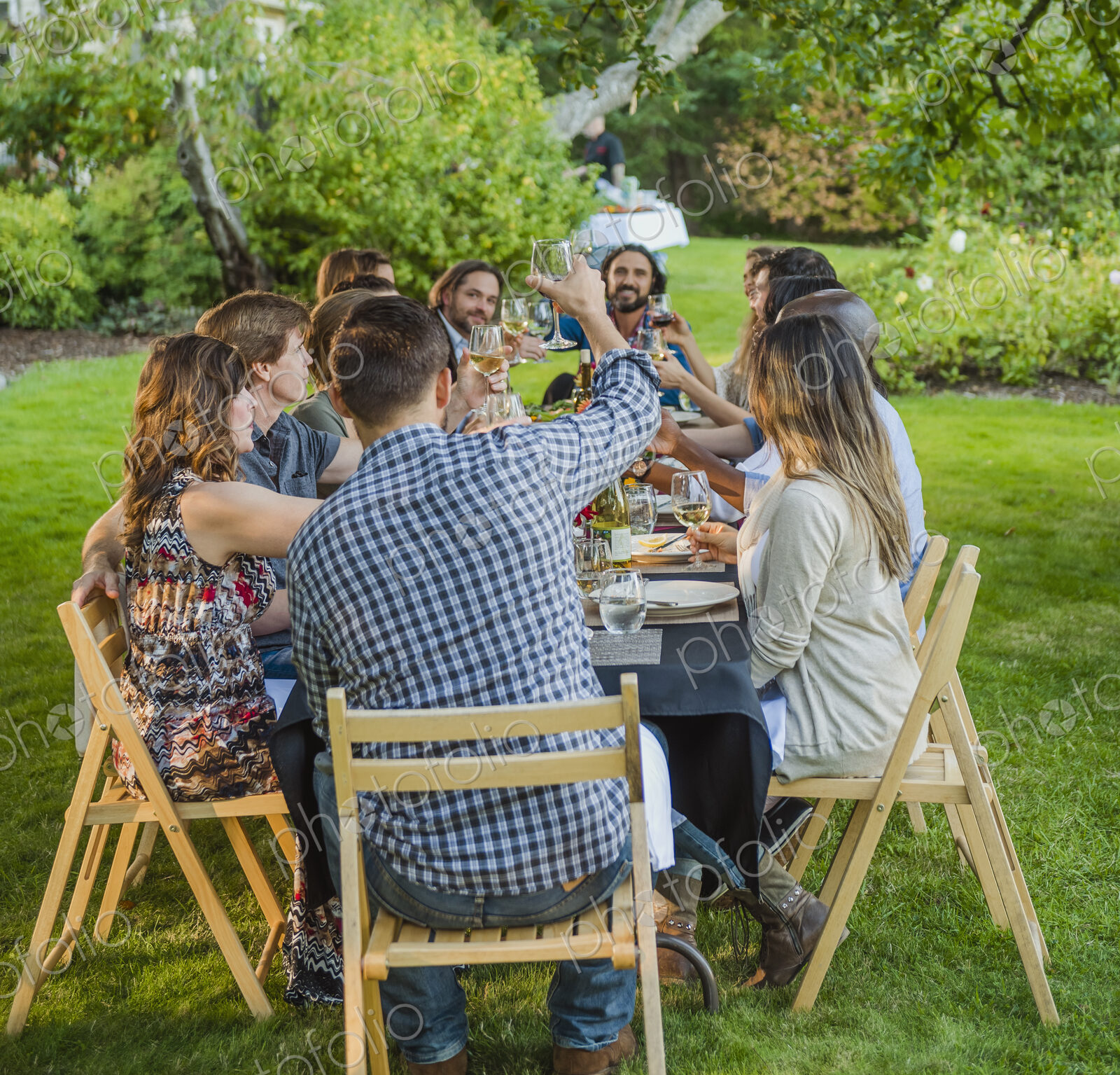 Friends toasting with wine at party outdoors