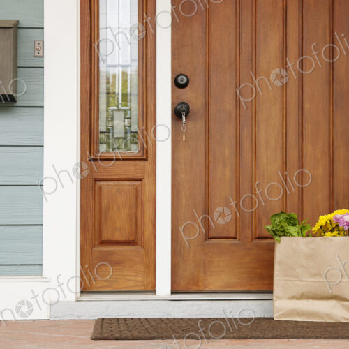 Front door of a house, postbox and a brown bag with flowers and vegetables, Welcome To… Front door of a house, postbox and a brown bag with flowers and vegetables, Welcome To…