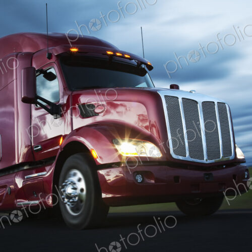Front to rear low angle view of the cab of a commercial truck on the highway late in… Front to rear low angle view of the cab of a commercial truck on the highway late in…