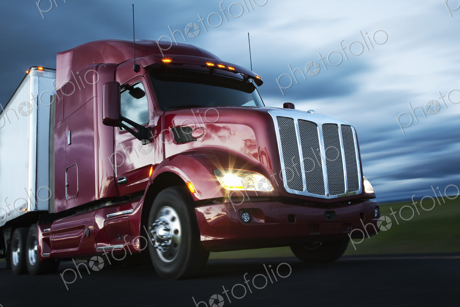 Front to rear low angle view of the cab of a commercial truck on the highway late in…