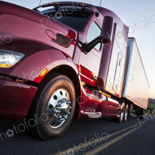 Front to rear low angle view of the cab of a commercial truck on the highway late in…